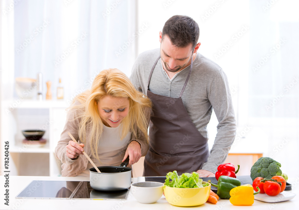 Young attractive woman give food to her husband to taste