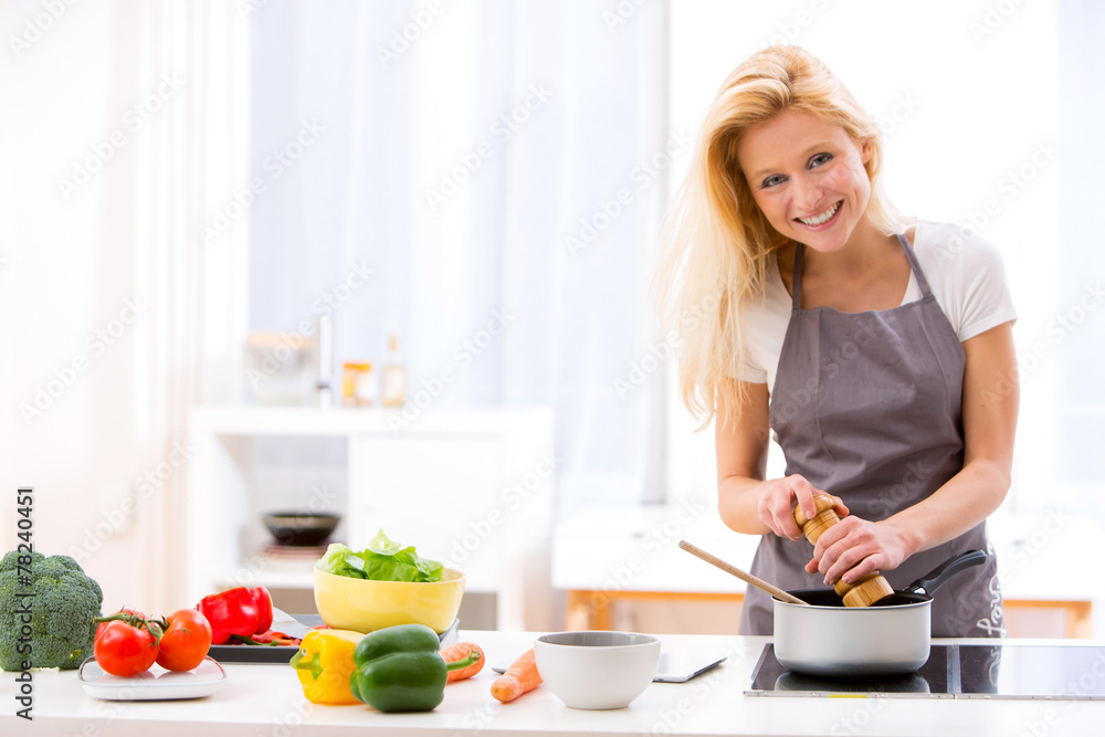 Young attractive woman cooking in a kitchen Young attractive woman cooking in a kitchen