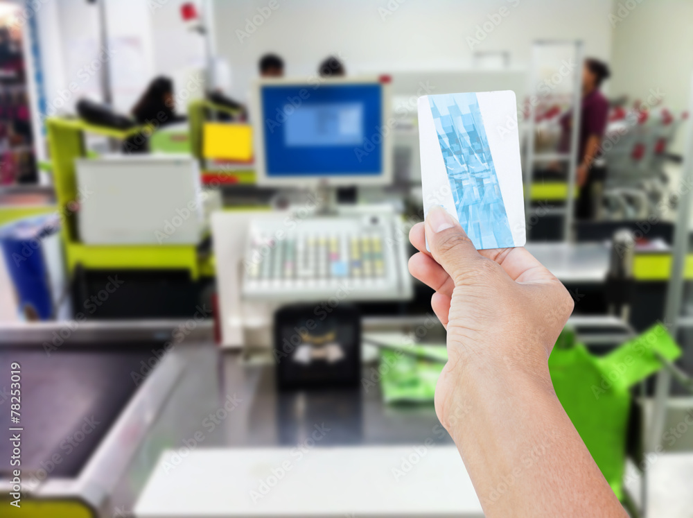 hand hold credit card on at cash register in supermarket