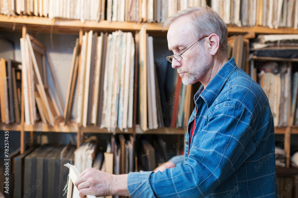 An artist in glasses preparing canvas An artist in glasses preparing canvas