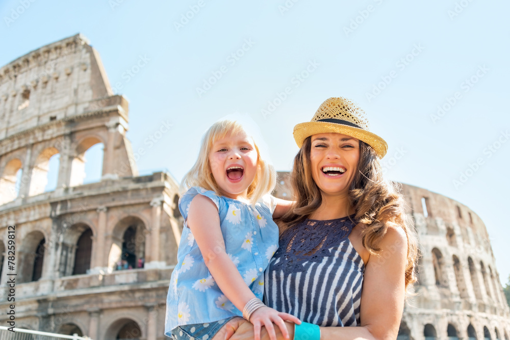 Naklejka premium Portrait of happy mother and baby girl in front of colosseum