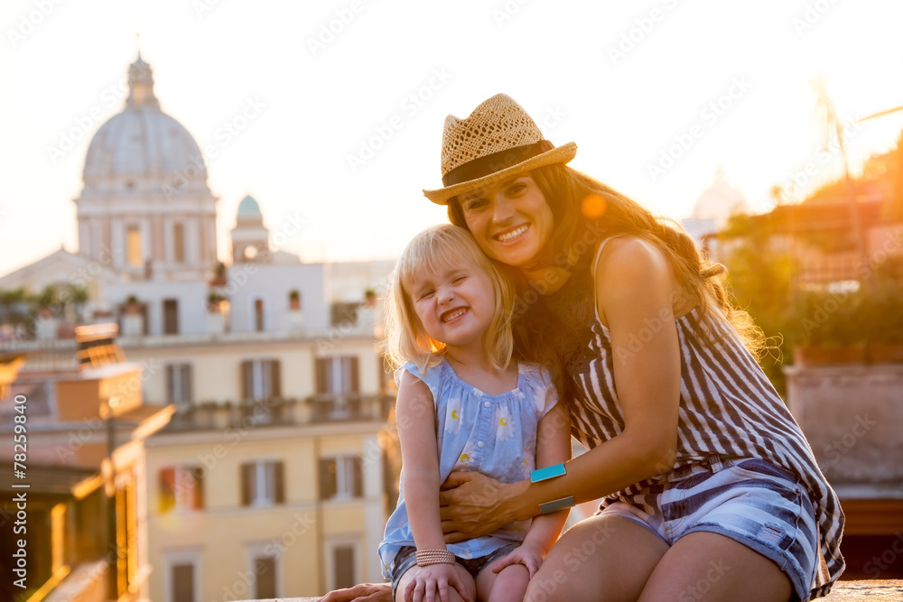 Portrait of mother and baby girl sitting on street  in Rome