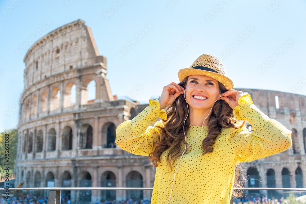 Naklejka premium Portrait of happy young woman with audio guide in Rome