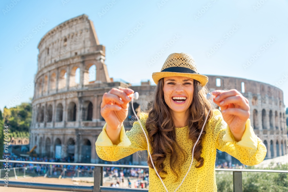 Fototapeta premium Happy young woman giving headphones with audio guide in Rome