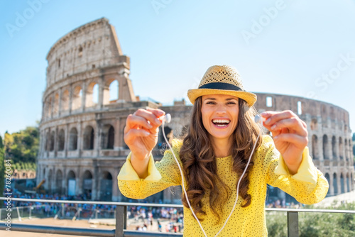 Happy young woman giving headphones with audio guide  in Rome photo