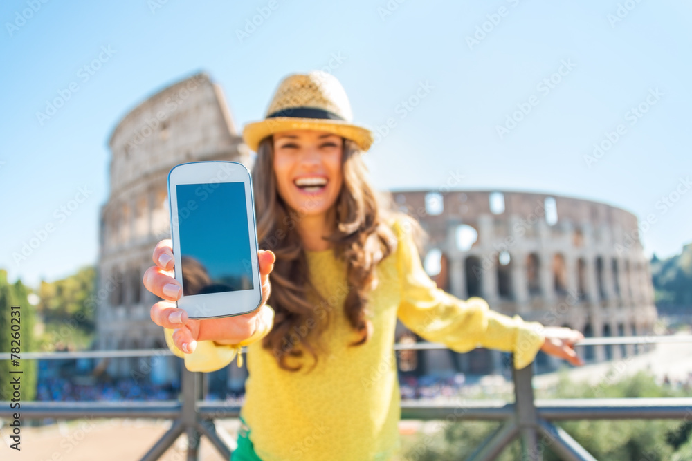 Fototapeta premium Closeup on happy young woman showing cell phone in Rome