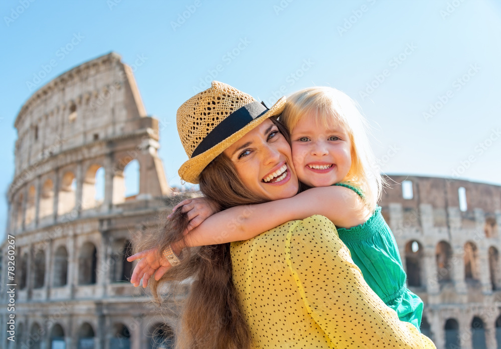 Obraz premium Portrait of mother and baby girl hugging in front of colosseum