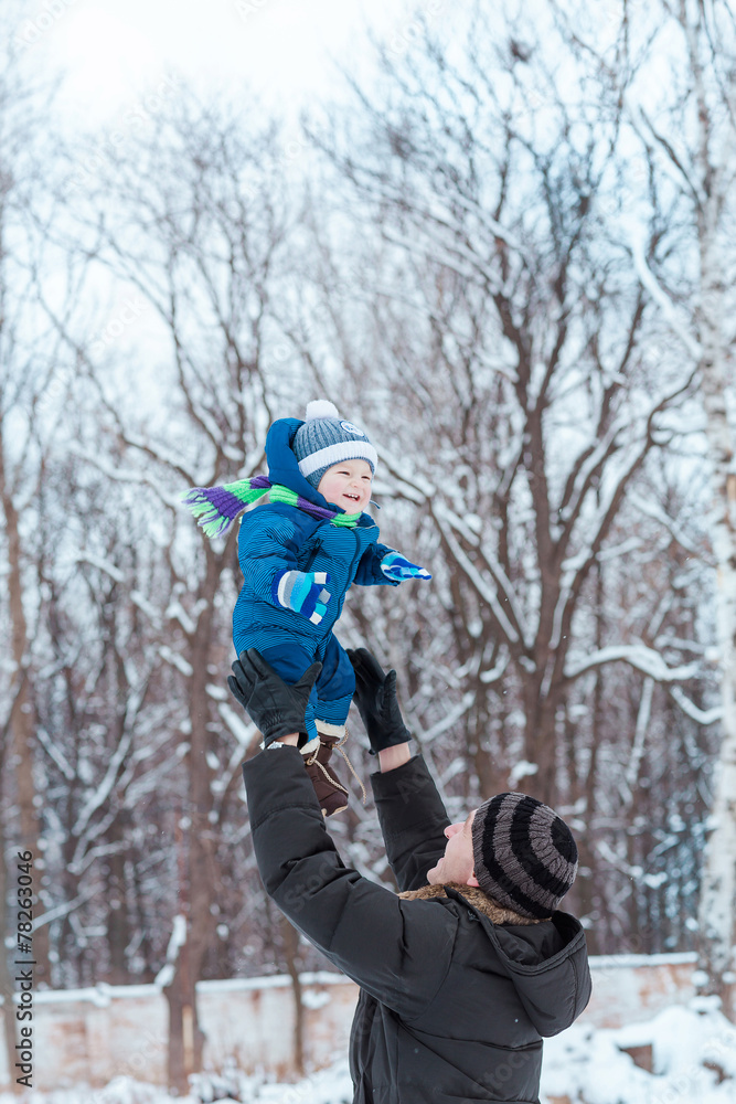 Happy father and baby playing on snow