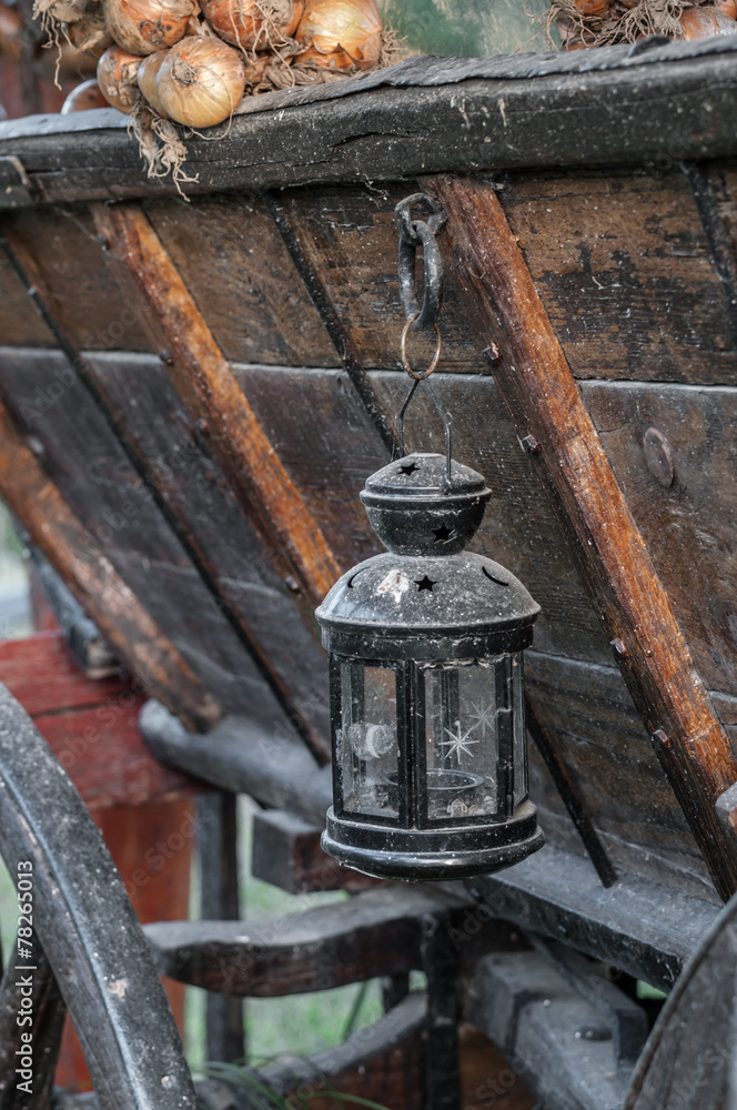 view of an old oil lamp hanging on a wooden carriage