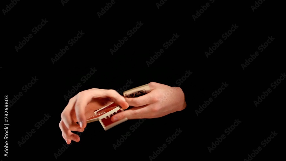 Magician making his trick with cards on black background Magician making his trick with cards on black background
