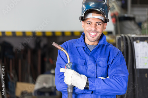 Professional welder posing with wellding machine photo