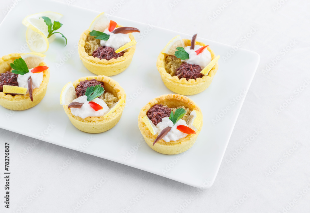 Salty mini tarts stuffed with green and black olive paste Salty mini tarts stuffed with green and black olive paste