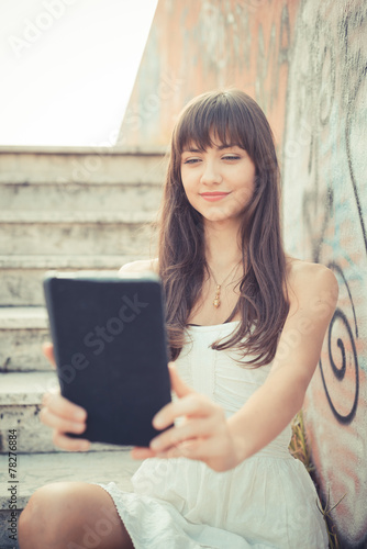 beautiful young woman with white dress using tablet