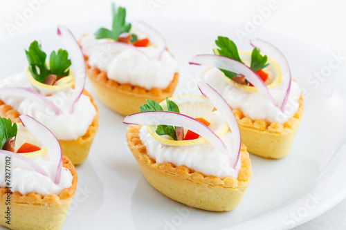 Salty mini tartlets stuffed with cream cheese and vegetable