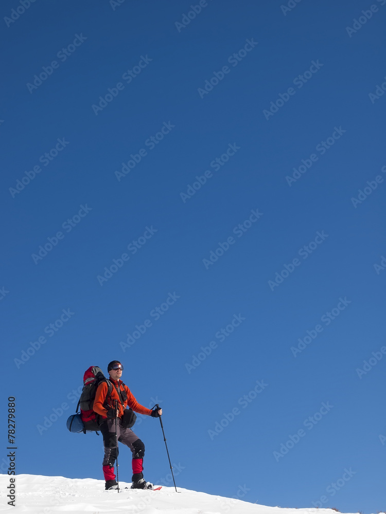 The man in snowshoes in the mountains. The man in snowshoes in the mountains.