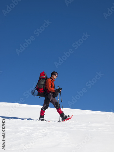 The man in snowshoes in the mountains.