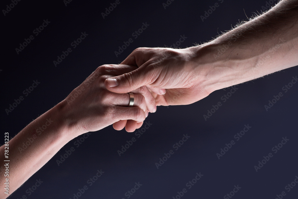 Helping male hand holds hand of a woman