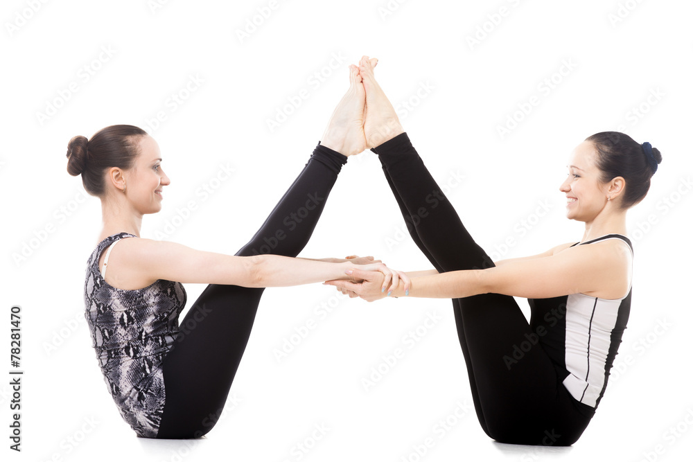 Two Yogi female partners in Balancing Stick yoga Pose Stock Photo