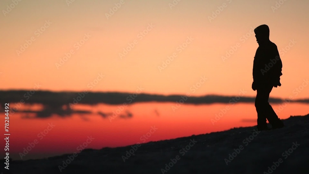 Man walking in the sunset at the mountains in winter Man walking in the sunset at the mountains in winter