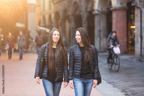 Obraz na plátně Female Twins Walking on Inner City Street