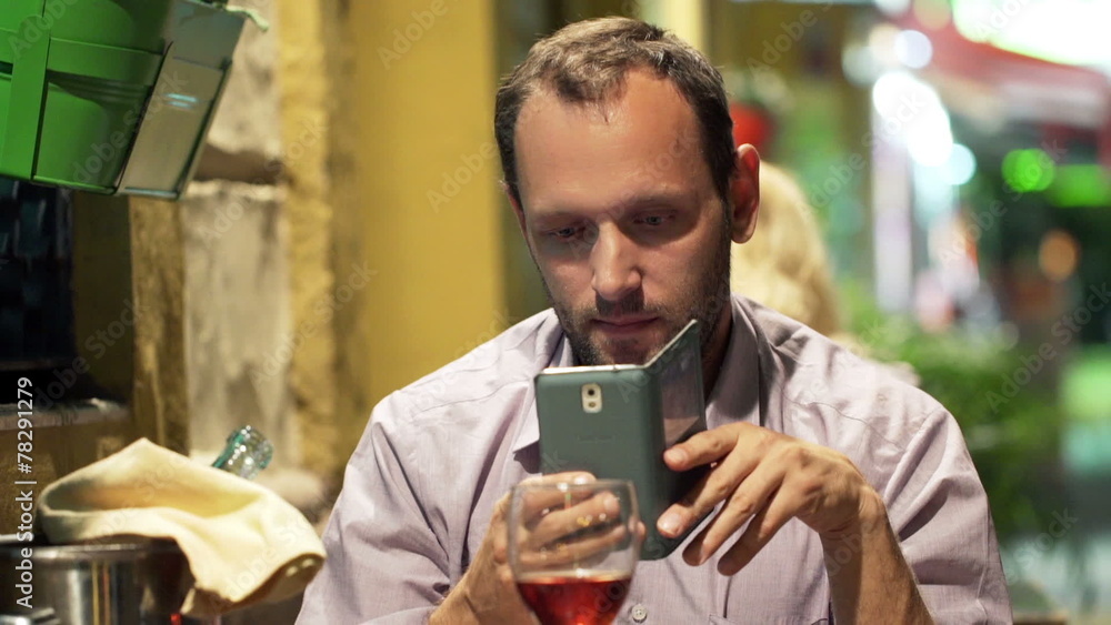 Young man taking photo of food with cellphone and drinking wine Young man taking photo of food with cellphone and drinking wine