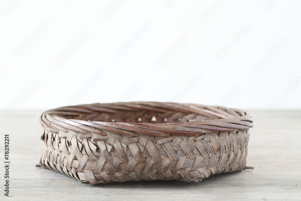 Flat basket on wooden table Flat basket on wooden table