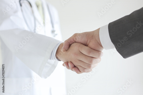 握手する医師とビジネスマン