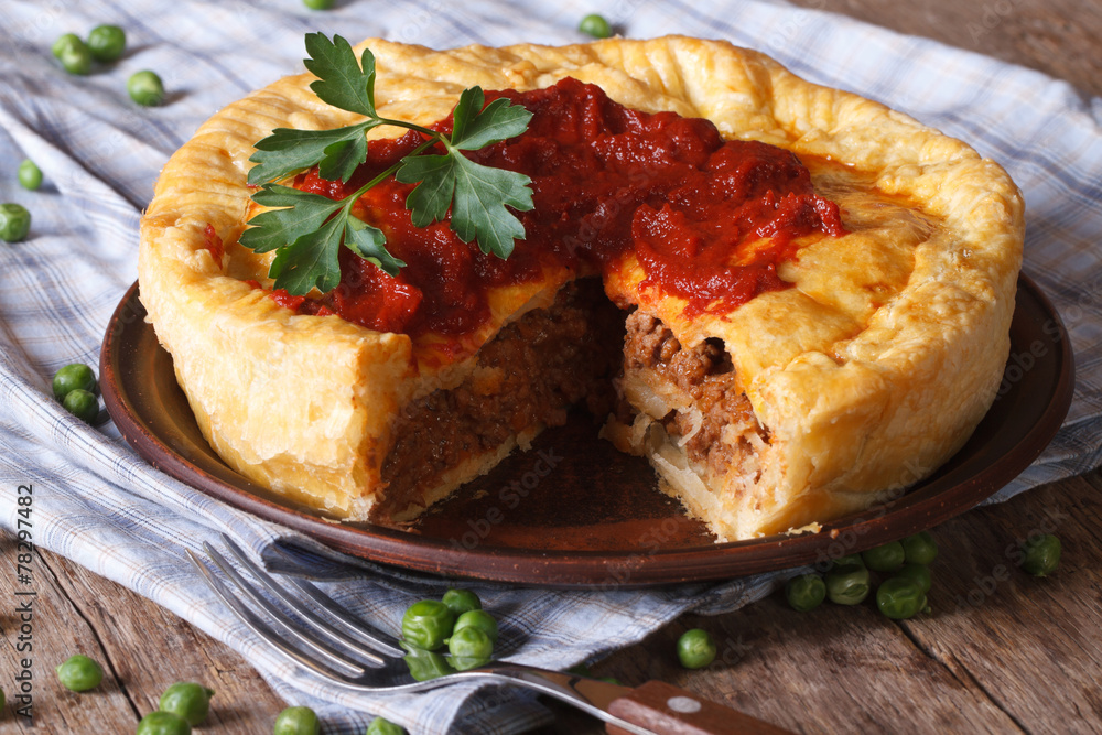 cut meat pie on a plate close-up. Horizontal