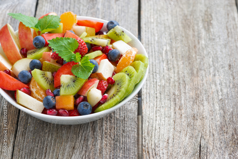 Fruit and berry salad in a bowl on a wooden background Fruit and berry salad in a bowl on a wooden background