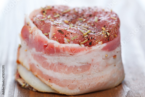 Steak with bacon and spices prepared for grilling.