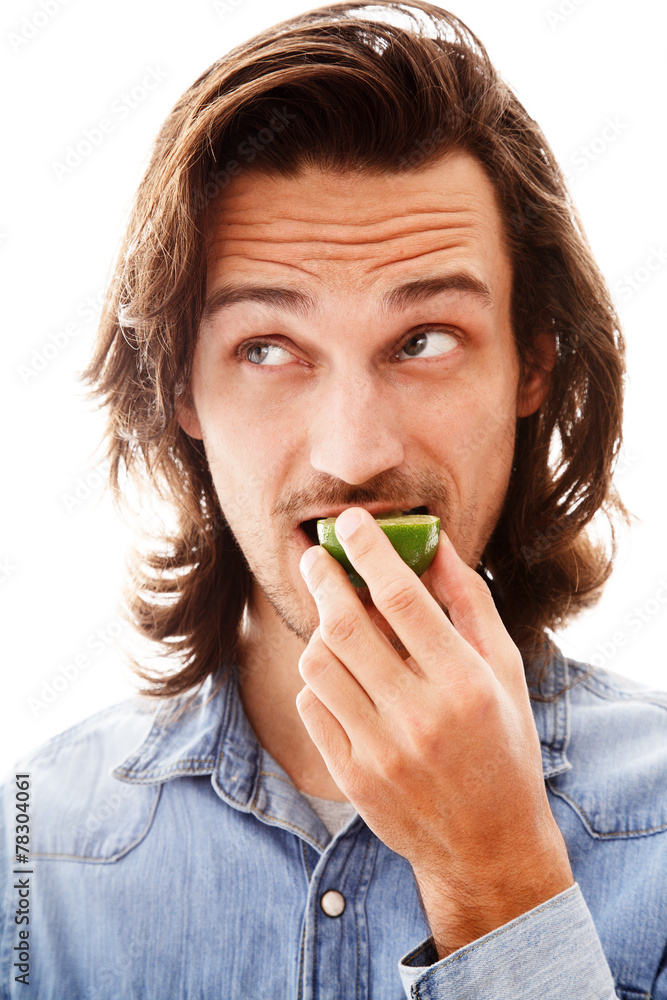 Young man eating a lime Young man eating a lime