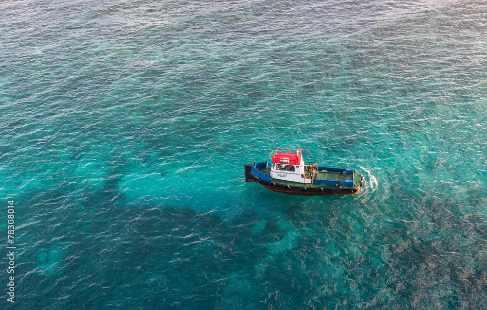 Red White and Blue Pilot Boat in Shallow Aqua Water Red White and Blue Pilot Boat in Shallow Aqua Water