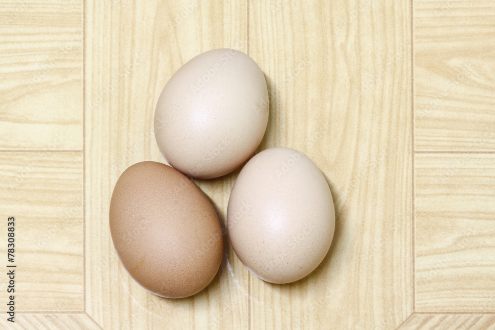 three eggs isolated on brown background