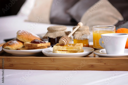 Tray with breakfast on a bed in a hotel room