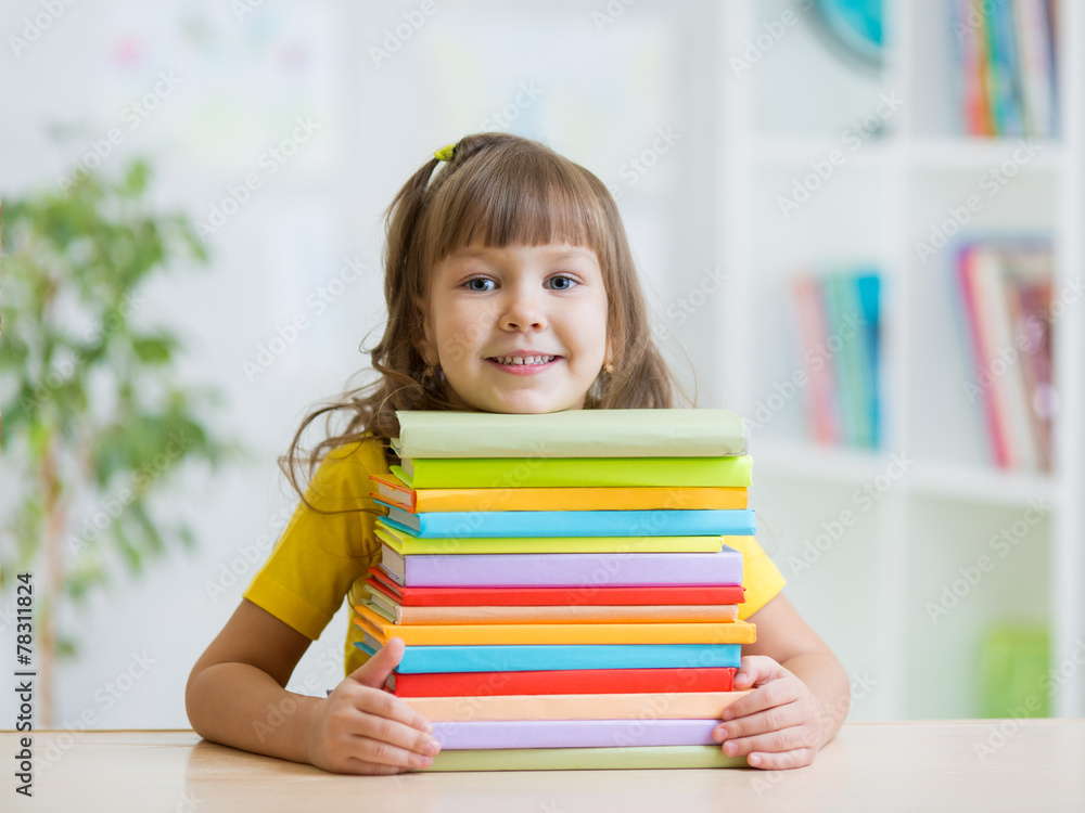 Happy kid girl with a stack of books Happy kid girl with a stack of books