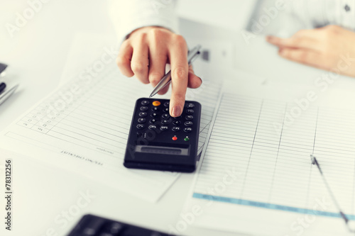 woman hand with calculator and papers