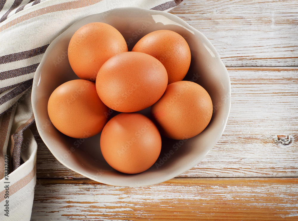 Raw brown eggs in a bowl.