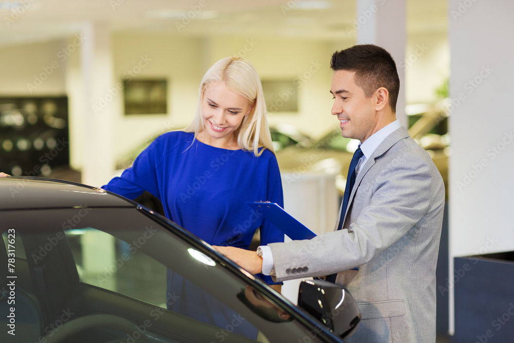 Obraz premium happy woman with car dealer in auto show or salon