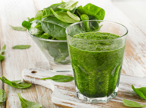 spinach smoothie in glass on a wooden background