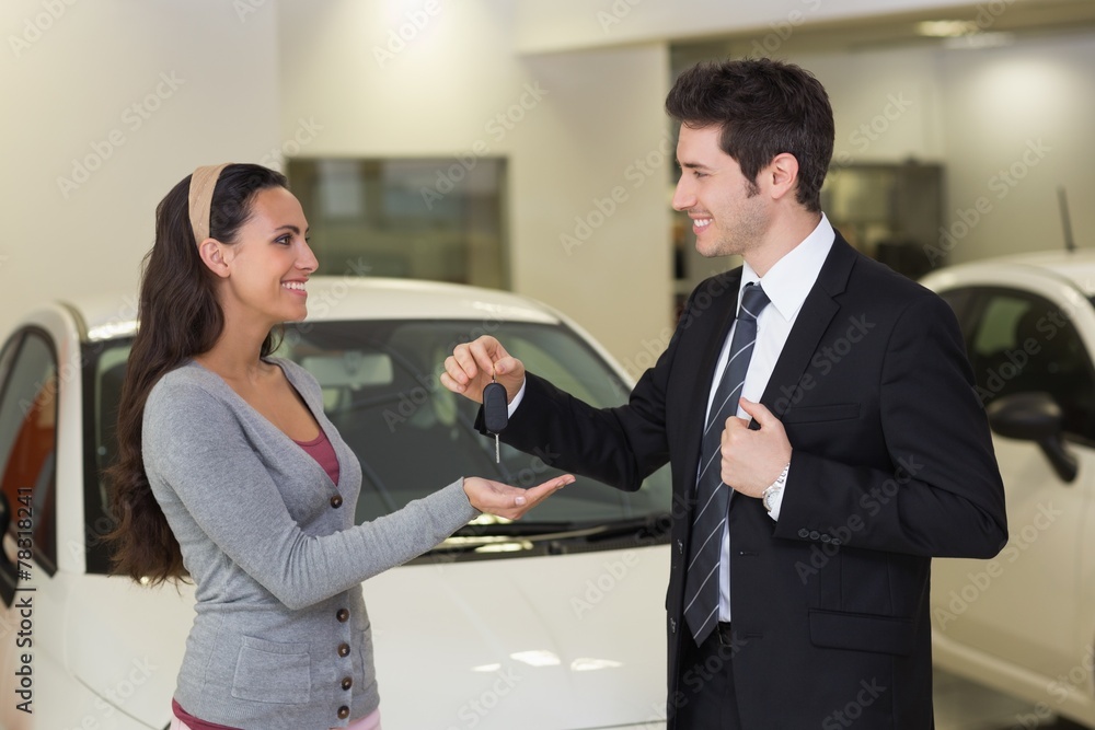 Smiling businessman giving car key to happy customer Smiling businessman giving car key to happy customer