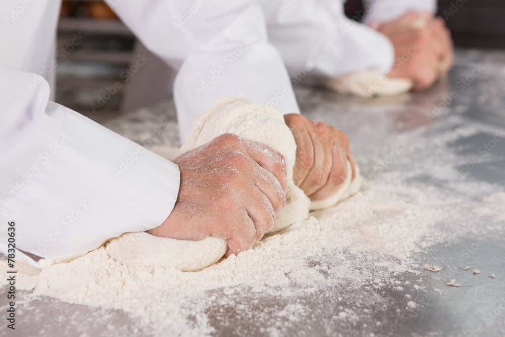 Close up of bakers kneading dough at counter Close up of bakers kneading dough at counter