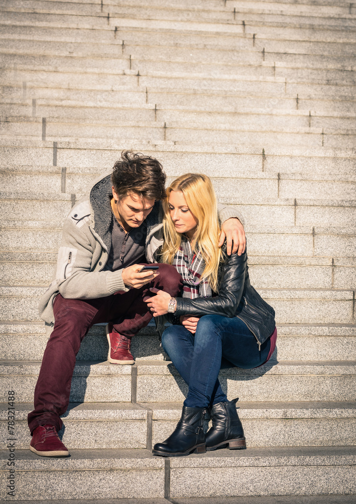 Hipster couple in love having fun with smartphone in urban area Hipster couple in love having fun with smartphone in urban area