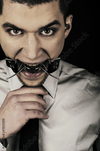 Portrait of man wearing grey sirt and tie, with bdsm spider photo