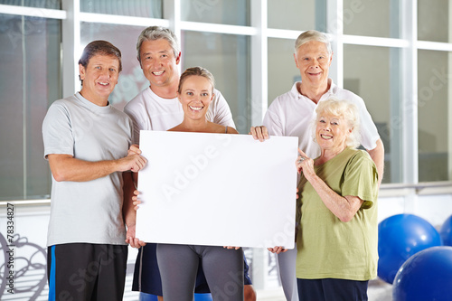 Gruppe Senioren hält Plakat im Fitnesscenter photo