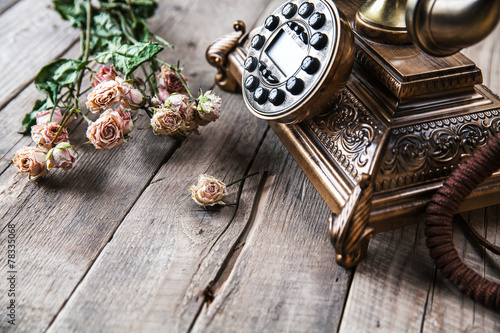 Old vintage black rotary phone and a bouquet of roses #78335068