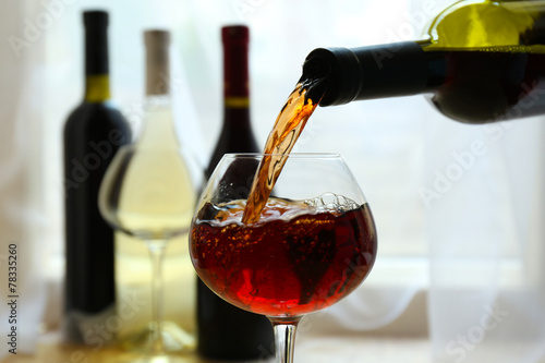Red wine pouring into wine glass, close-up