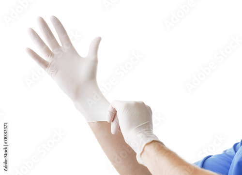 Doctor putting on sterile gloves isolated on white photo