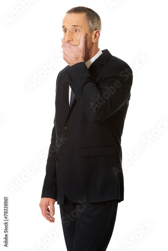 Shocked businessman covering his mouth