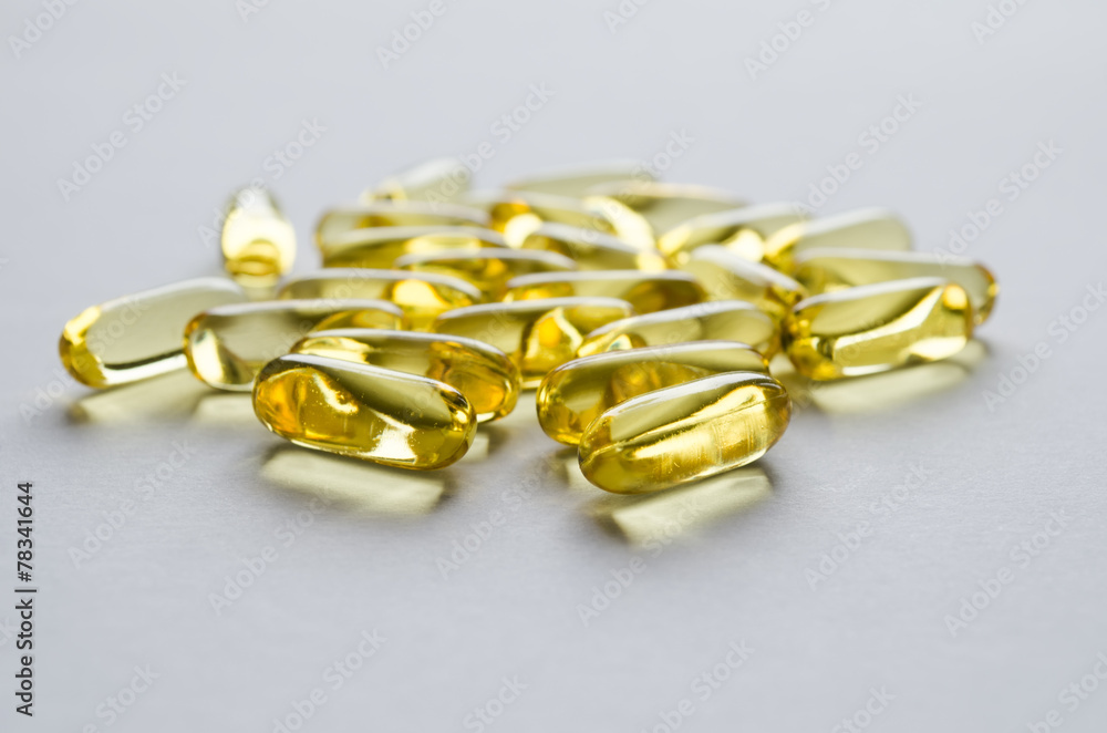 Close-up yellow transparent capsules on a gray background Close-up yellow transparent capsules on a gray background