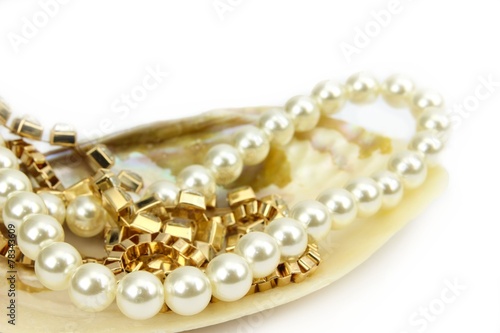 Perlenkette und Goldschmuck in Muschel